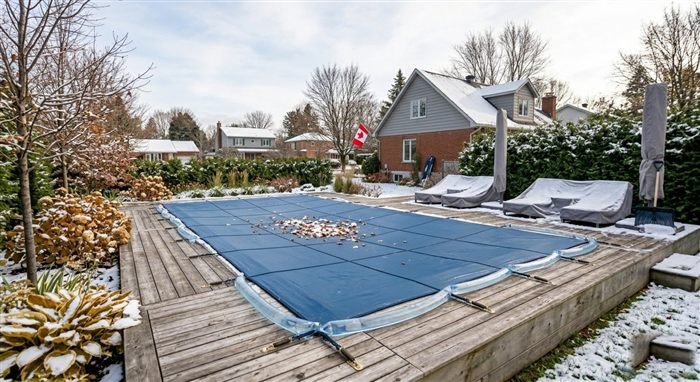Piscine hivernée avec toile de sécurité, paysage automnal québécois
